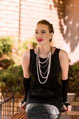 Young female model in black dress in Breakfast at Tiffany's style