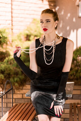 Young female model in black dress in Breakfast at Tiffany's style