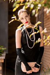 Young female model in black dress in Breakfast at Tiffany's style