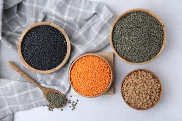 Different types of lentils on light table, flat lay