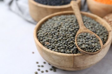 Different types of lentils on light table, closeup