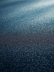 Textured Asphalt Abstract: A close-up shot of textured asphalt. The road surface with subtle variations, is bathed in cool light, conveying a sense of depth and abstraction.