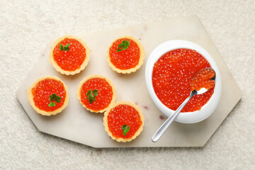 Tartlets with red caviar and parsley on beige background, top view