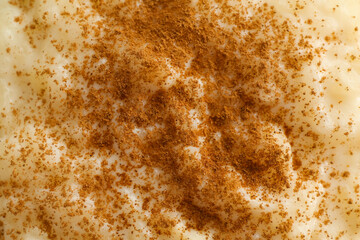 Delicious rice pudding with cinnamon as background, closeup