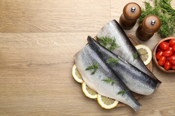 Tasty herring fillets with dill and lemon slices on wooden table, flat lay. Space for text