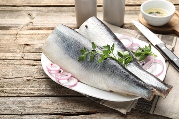 Tasty herring fillets with spices on wooden table, closeup