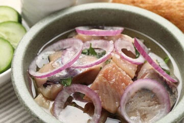 Pieces of delicious herring with onions on table, closeup