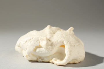 Delicious homemade meringue cookie on gray background, closeup