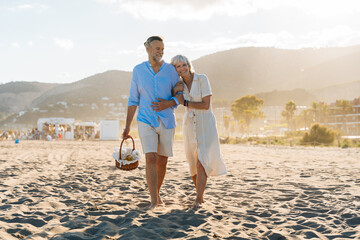 Beautiful happy senior couple dating at the seaside during summertime