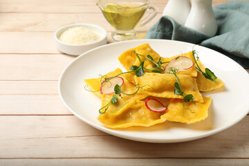 Delicious ravioli with microgreens and radish on wooden table, closeup