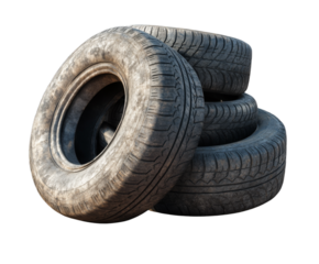 Four used tires of different conditions are stacked on top of each other against a plain white background. The tires show signs of wear and are ready for disposal or recycling