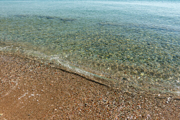 Pebble coast and waves in Datca, Turkey.  Clear water of the Mediterranean coast of Turkey.