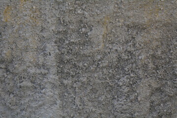 Textured surface in urban setting displays weathered patterns with a blend of gray and yellow tones throughout
