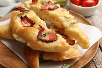 Slices of delicious focaccia bread with bacon and rosemary on table, closeup