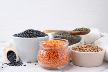 Different types of lentils on white table