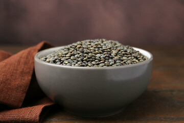 Raw green lentils on wooden table, closeup