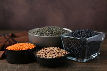 Different types of lentils on wooden table