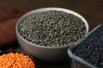 Different types of lentils on wooden table, closeup