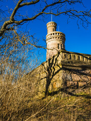 Old water tower standing tall amidst overgrown vegetation in Gothenburg on a bright sunny day