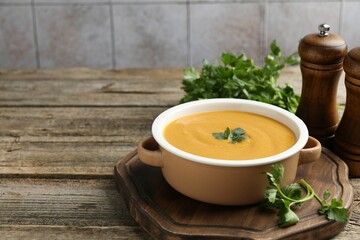 Delicious lentil cream soup with parsley on wooden table. Space for text