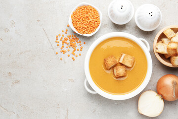 Delicious lentil cream soup served with croutons on light grey table, flat lay. Space for text