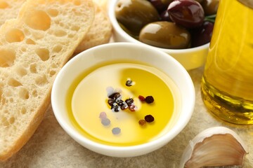 Slices of bread with oil, spices and olives on light table, closeup