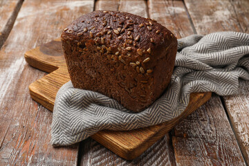 Fresh loaf of bread on wooden table, closeup