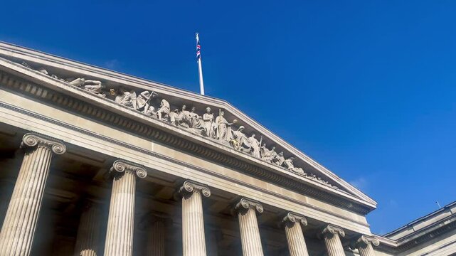 The British Museum grand neoclassical facade with towering columns beneath a clear London sky on a sunny day