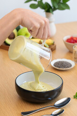 Preparing healthy avocado smoothie in kitchen setting
