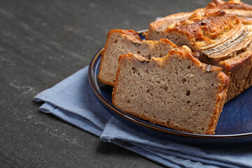 Cut banana bread with nuts on black table, closeup. Space for text