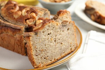 Cut banana bread with nuts on table, closeup