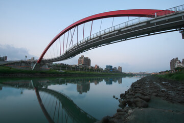 Obraz premium A view of Taipei's Rainbow Bridge at twilight, a pedestrian-only bridge spanning the Keelung River in Taiwan.