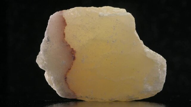 Yellow Calcite sample rotating against a black background.	
