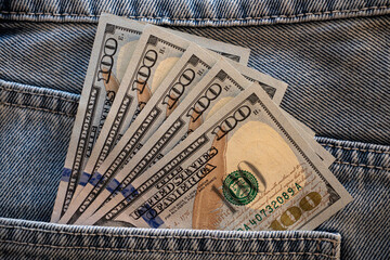 Cash neatly tucked in a denim pocket shows wealth and style