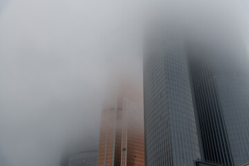 Skyscrapers partially hidden by fog on a misty urban morning