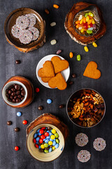 Various sweet food on black chalkboard background. Flat lay. Top view. Food concept.