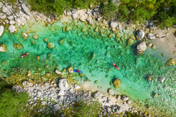 Kayakers on Soca river in Slovenia. Aerial top down tracking shot