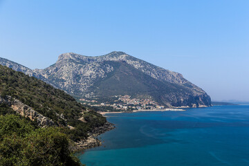 A mountain range with a blue sea in the background on the island Sardinia in Italy