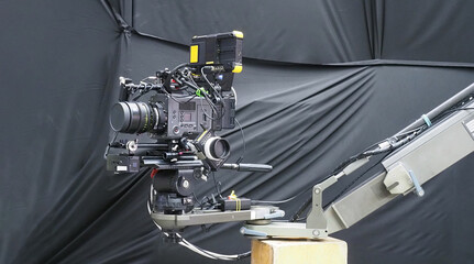 A cinema camera mounted on a mechanical camera crane, equipped with a high end lens
