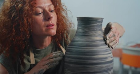 Potter shapes a beautiful striped vase in an art studio during a creative session on pottery making