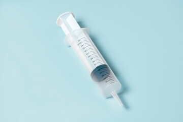 Huge syringe without needle on blue background. Symbolizes research and innovation in medicine.