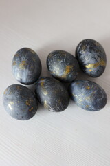 Black-blue Easter eggs with gold brushstrokes on a light background. Stylish, modern, and minimalist holiday design for Easter decoration or celebration themes