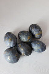 Black-blue Easter eggs with gold brushstrokes on a light background. Stylish, modern, and minimalist holiday design for Easter decoration or celebration themes