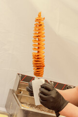 Chef holds a wooden skewer with Tornado potato or twist potato sold on the street,street food