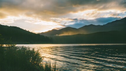 Fototapeta premium Golden light paints the mountains and lake.