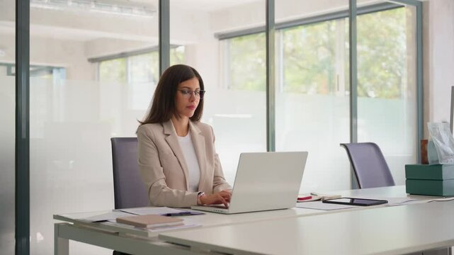 Concentrated latin hispanic woman using computer technology for work online. Young professional it specialist latin hispanic business lady working on laptop pc sitting at desk in modern office. Wide 