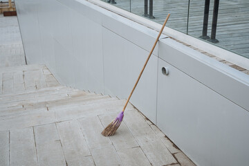On a tiled floor, there is a broom that features a striking purple handle, making it a colorful...