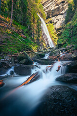 waterfall in the alps with cascade river flow in front long exposure