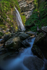 waterfall in the alps with cascade river flow in front long exposure