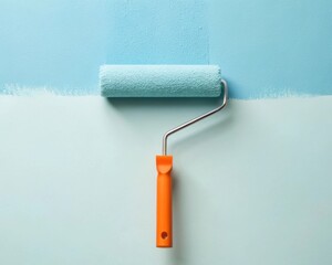 Obraz premium A paint roller rests against a freshly painted wall in two shades of blue.